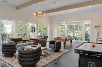 A room with a pool table and a shelf with a clock on it.